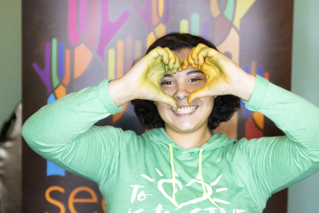 happy girl making heart symbol with hands
