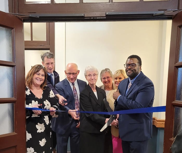 Sister and group cutting ribbon for Angela's House opening.